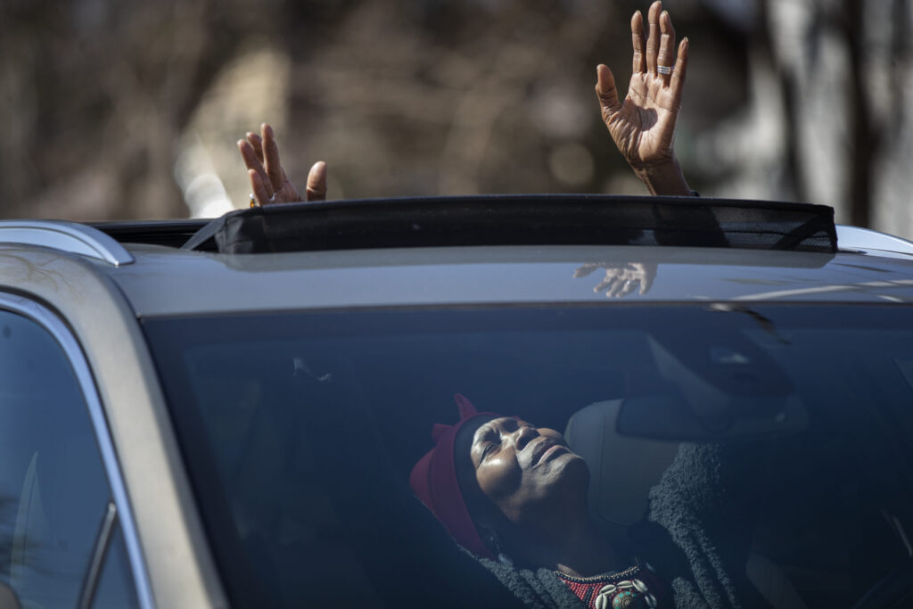 Peggie Hicks raised her hands in prayer through the sunroof of her car during "Park and Praise" service at New Hope Baptist Church in St. Paul, Minn., on Sunday, April 19, 2020