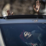 Peggie Hicks raised her hands in prayer through the sunroof of her car during "Park and Praise" service at New Hope Baptist Church in St. Paul, Minn., on Sunday, April 19, 2020