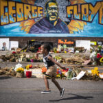 Carter Sims, 3, of Pine Island ran past a mural at the George Floyd memorial outside Cup Foods in Minneapolis, Minn., on June 25, 2020, exactly one month after George Floyd died at the corner