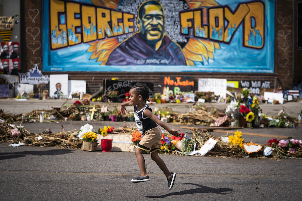 Carter Sims, 3, of Pine Island ran past a mural at the George Floyd memorial outside Cup Foods in Minneapolis, Minn., on June 25, 2020, exactly one month after George Floyd died at the corner