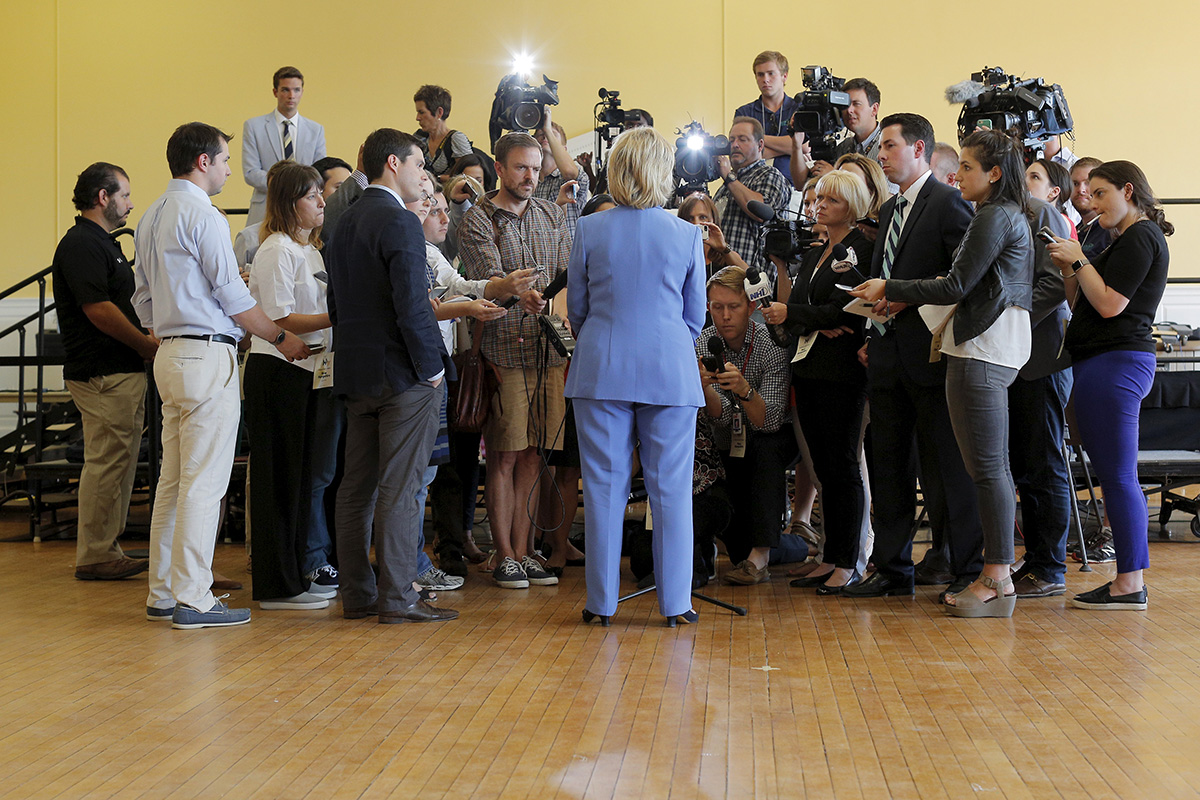 Hillary Clinton, seen from behind, speaks to a crowd of reporters at a town hall meeting in Dover, New Hampshire