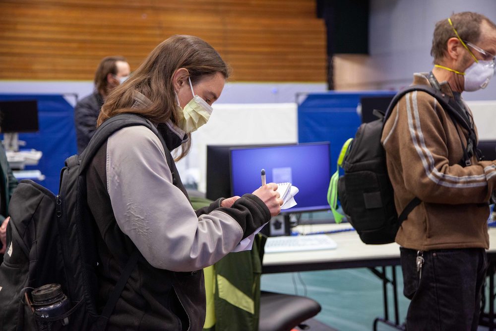 A health care reporter takes notes while on assignment