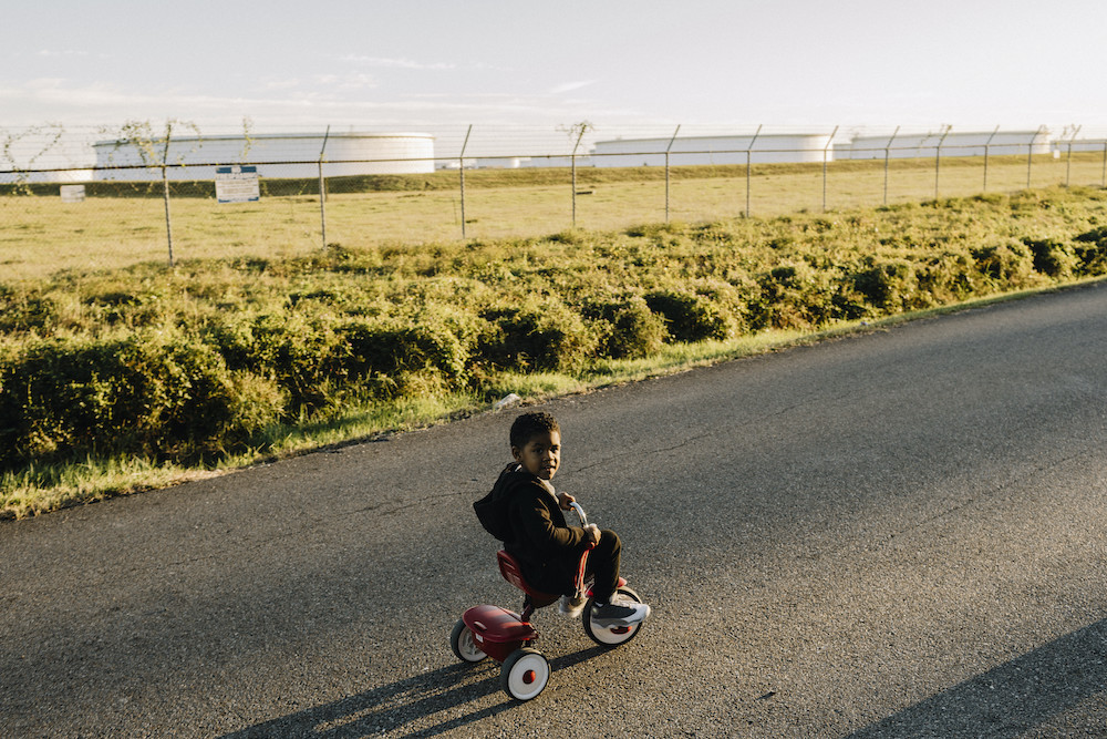 Boy on trike in "Cancer Alley"