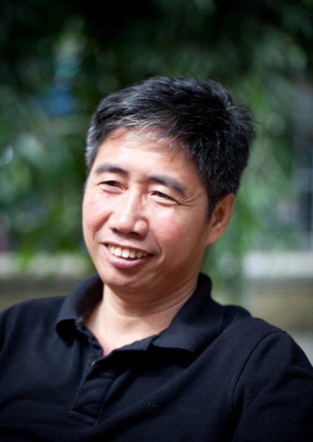 headshot of Truong Huy San wearing a black polo shirt 