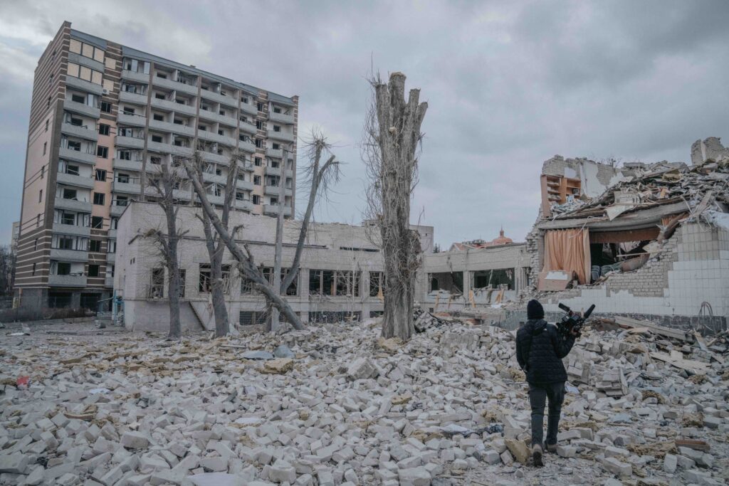 a man looks out on the rubble after a Russian airstrike in Ukraine, the sky is gray