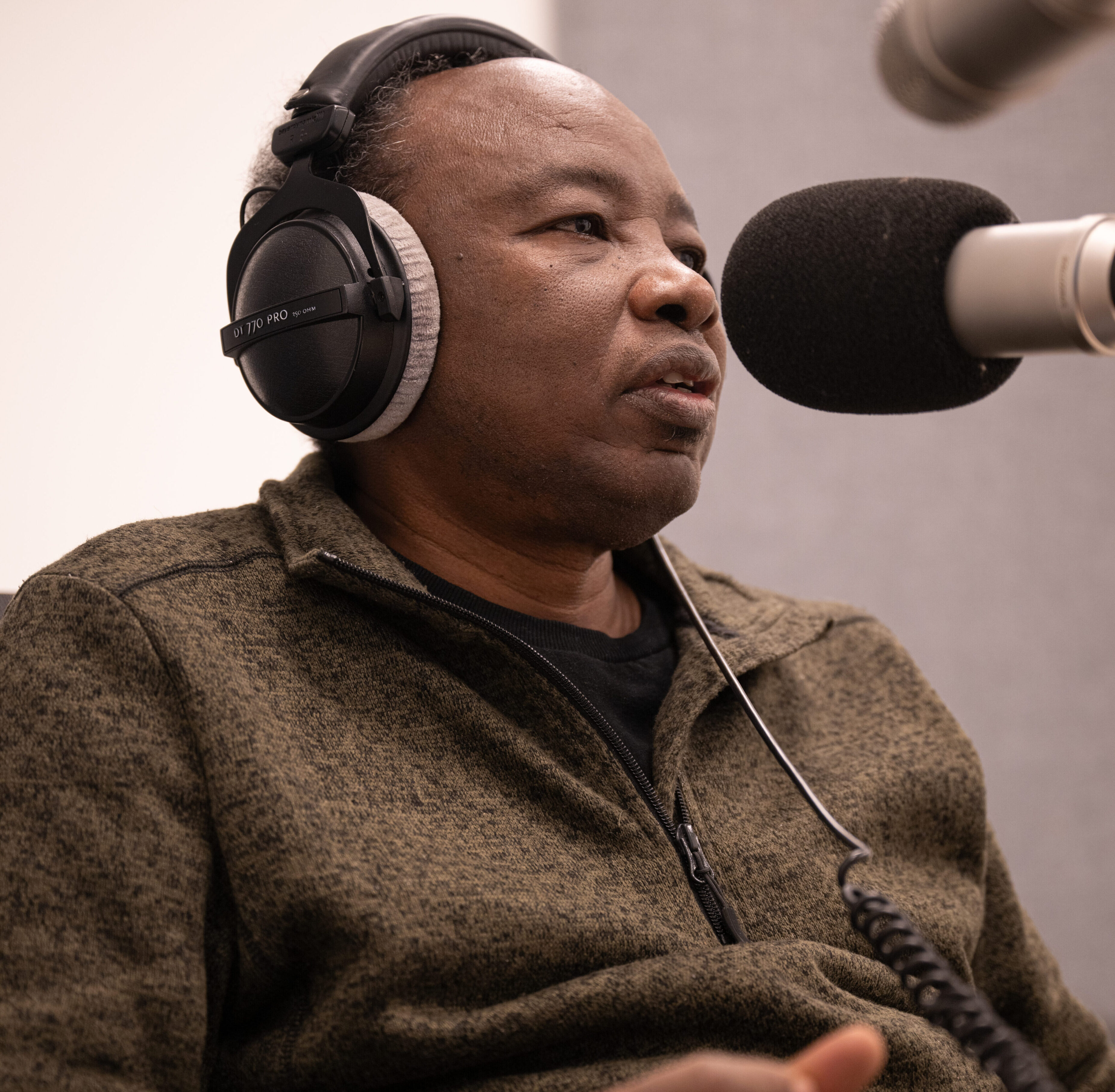 a man sits at a microphone in a professional podcasting studio