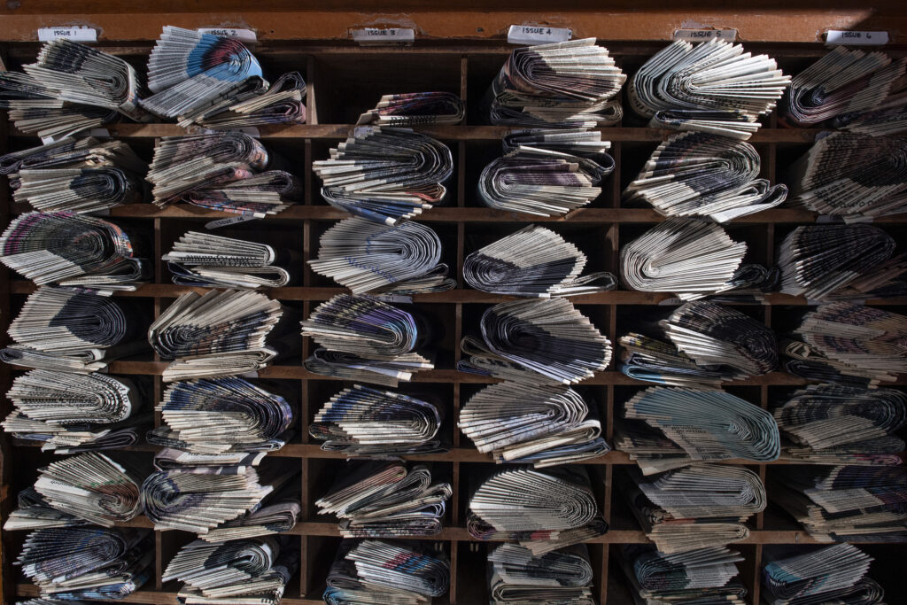 dozens of newspapers in individual cubby holes