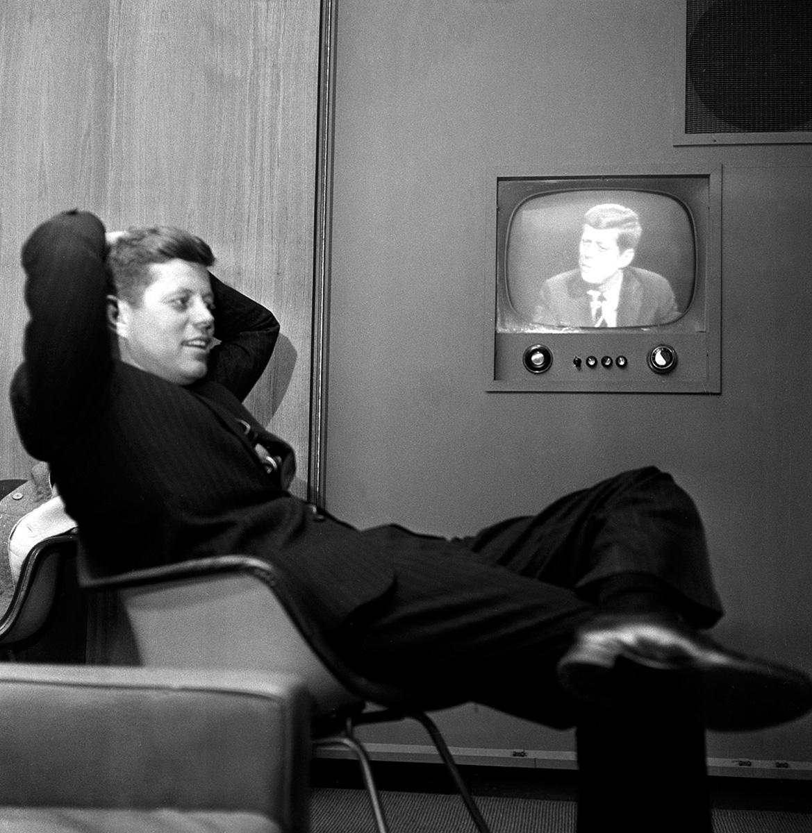 On the TV screen, a playback of Democratic presidential nominee John F. Kennedy’s campaign stop in 1960