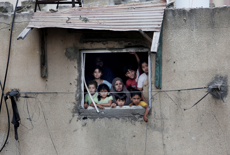 A Palestinian family watches rescuers after an Israeli missile strike in Gaza City