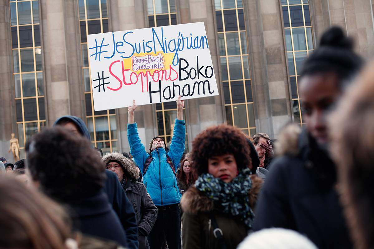 Protesters in Paris adapt a Charlie Hebdo slogan to highlight a January 7 Boko Haram massacre