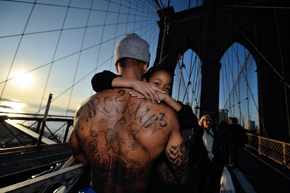 Jerell Willis carries his son Fidel across the Brooklyn Bridge. Jerell is a single father living on the Lower East Side, who went through a long and arduous legal process to obtain full custody of his son. Brooklyn, New York, November 2012.