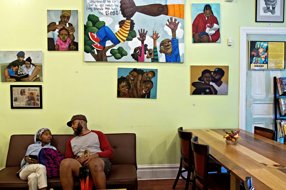 Artist Cbabi Bayoc at his SweetArt Bake Shop with his daughter Jurni in St. Louis, Missouri. The shop is only a few blocks away from the site of the October 8, 2014, Vonderrit Myers shooting. Bayoc opened his shop after hours during times of unrest to provide a safe haven for anyone residents and protesters.