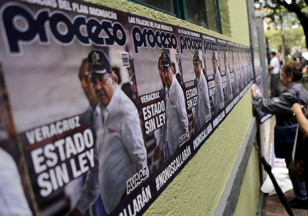 Activists put up posters with an image of Veracruz state governor Javier Duarte that reads, "Lawless State"