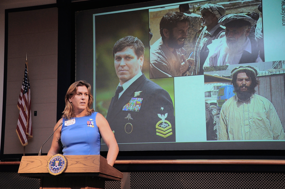 Kristin Beck, a transgender former Navy SEAL, shares images from her past during a talk at an FBI office in Clarksburg, West Virginia