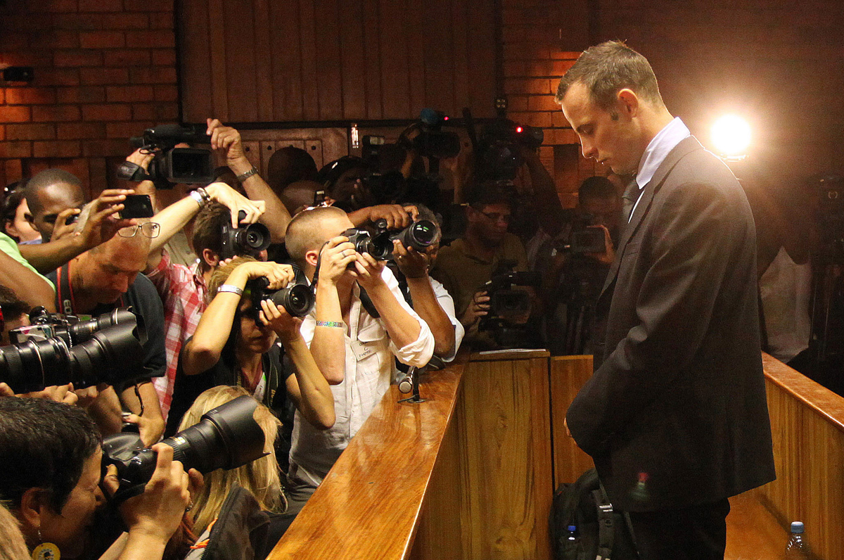 FILE - In this Friday, Feb 22, 2013 file photo photographers take photos of Olympic athlete Oscar Pistorius as he appears at a bail hearing for the shooting death of his girlfriend Reeva Steenkamp, in Pretoria, South Africa. (AP Photo/Themba Hadebe-File)