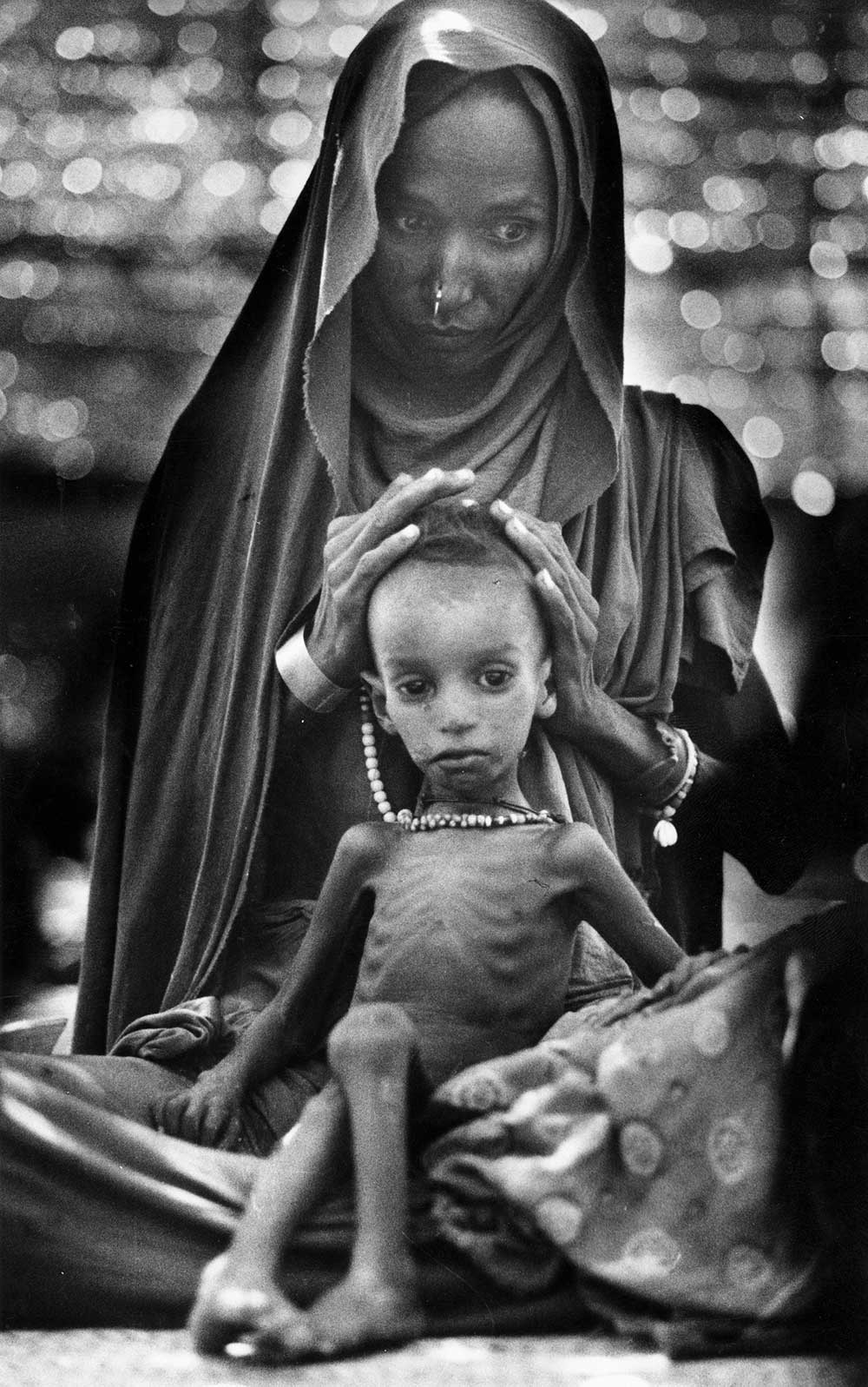 An Ethiopian mother and child await food in a Sudanese refugee camp in 1984