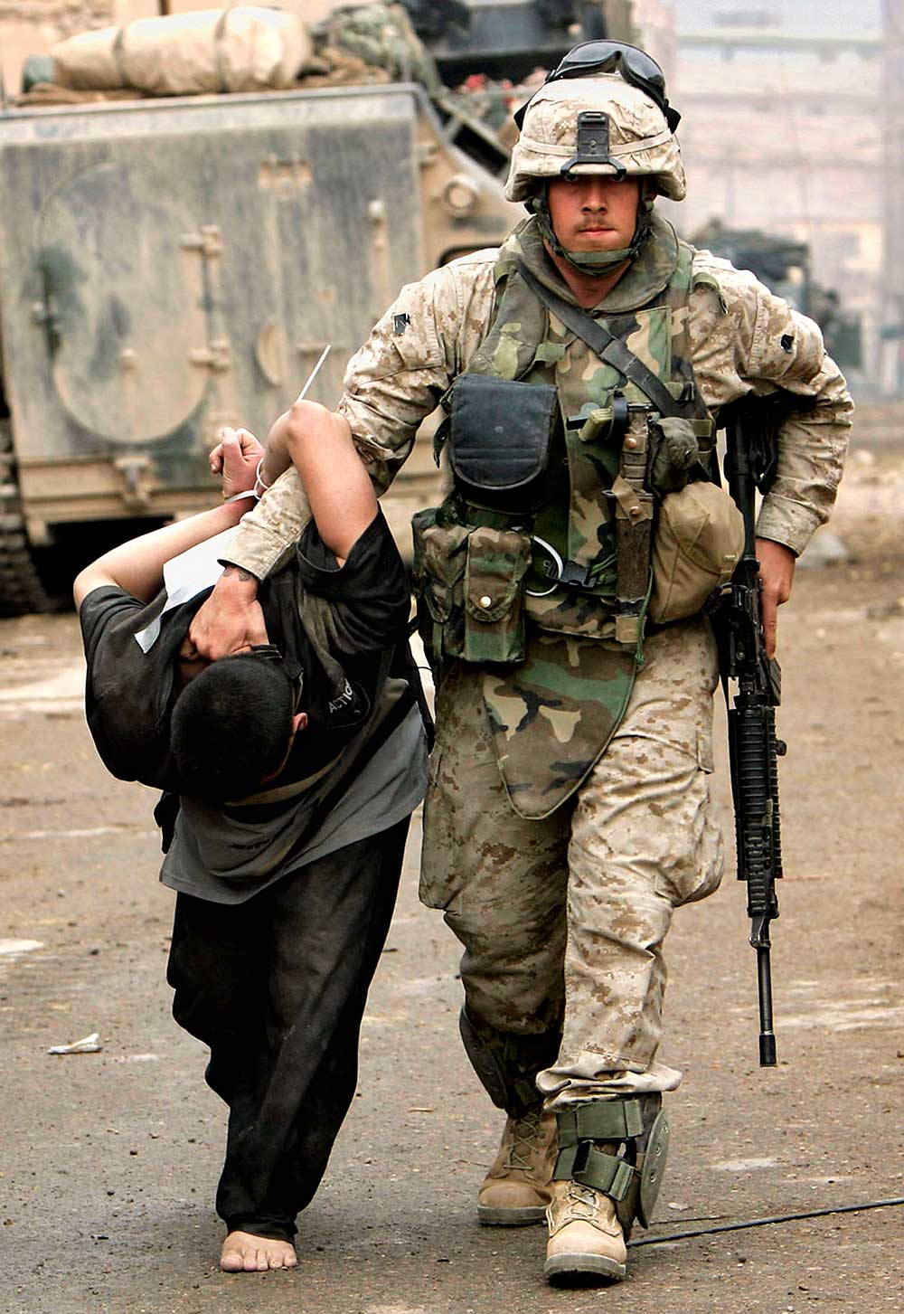 A U.S. Marine leads away a captured Iraqi man in Fallujah, Iraq, in 2004
