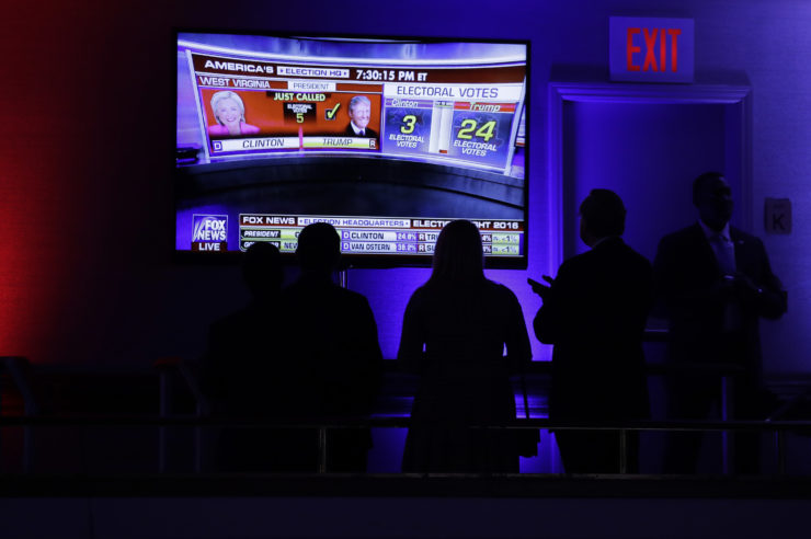 Supporters gather around the monitor to check the early election results during Republican presidential candidate Donald Trump's election night rally in New York