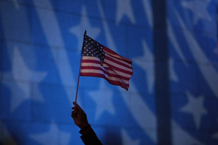Howard Nizebeth waves a U.S. flag during an Election Day gathering at Rockefeller Center in New York