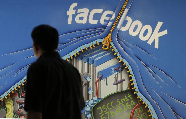 A man walks past a mural in an office on the Facebook campus in Menlo Park, California