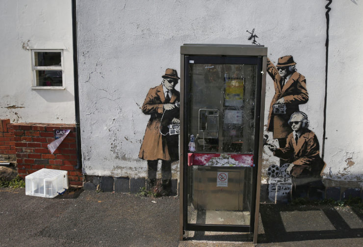Graffiti—attributed to the acclaimed street artist Banksy—on a wall near Britain’s eavesdropping agency is a spoof on Snowden’s claim that the agency shared intercepted information with the NSA