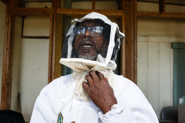 A man named J.R. checks the fit of his bee-keeping suit. J.R. takes care of bees and a community garden in Atlanta, Georgia