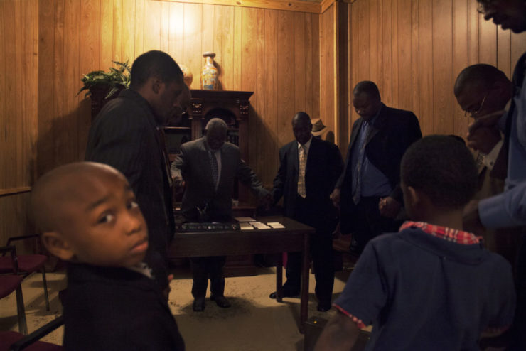 Male members at a Seventh-Day Adventist Church in Turrell, Arkansas join hands in prayer