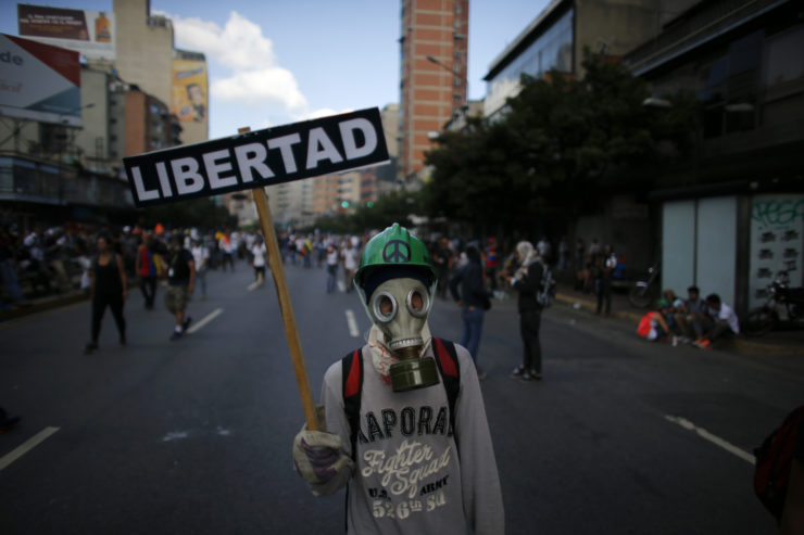 Un manifestante enmascarado sostiene una pancarta que dice “Libertad”, durante enfrentamientos con las fuerzas de seguridad del gobierno en Caracas, en mayo. La censura en Venezuela se ha incrementado mientras la crisis política se agudiza