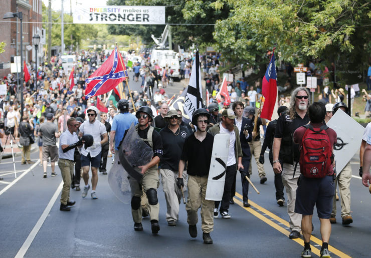 White nationalist demonstrators walk through town after their rally was declared illegal near Lee Park in Charlottesville