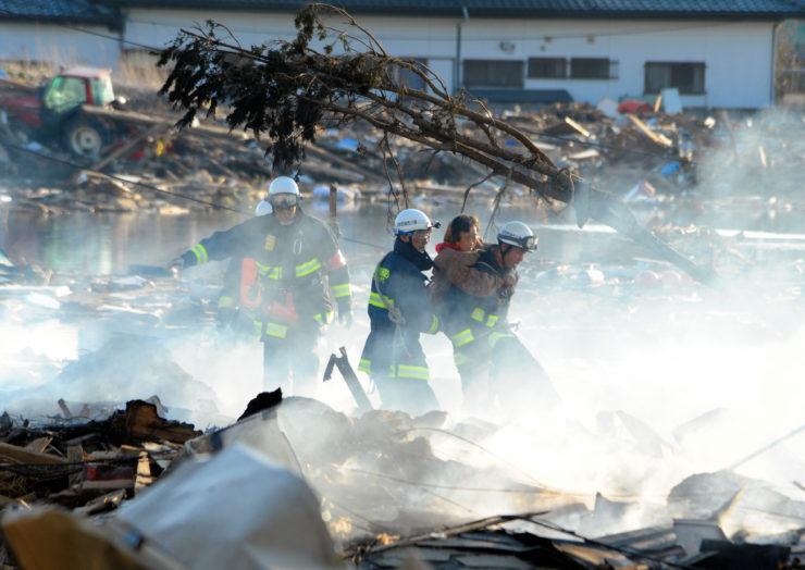 Firefighters rescue a woman from smoking ruble in Natori, Miyagi a day after the 2011 earthquake and subsequent tsunami struck Japan. While photo coverage of American tragedies often depicts people acting heroically, the same is rarely true in U.S. coverage of foreign crises