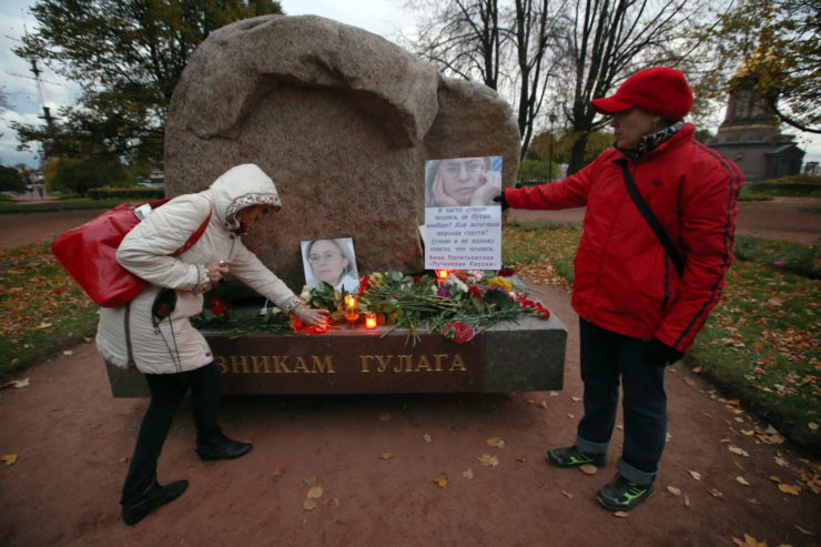 Flowers and candles surround a portrait of Anna Politkovskaya, a Russian journalist who was murdered in 2006, at the Solovetsky Stone in St. Petersburg in 2016