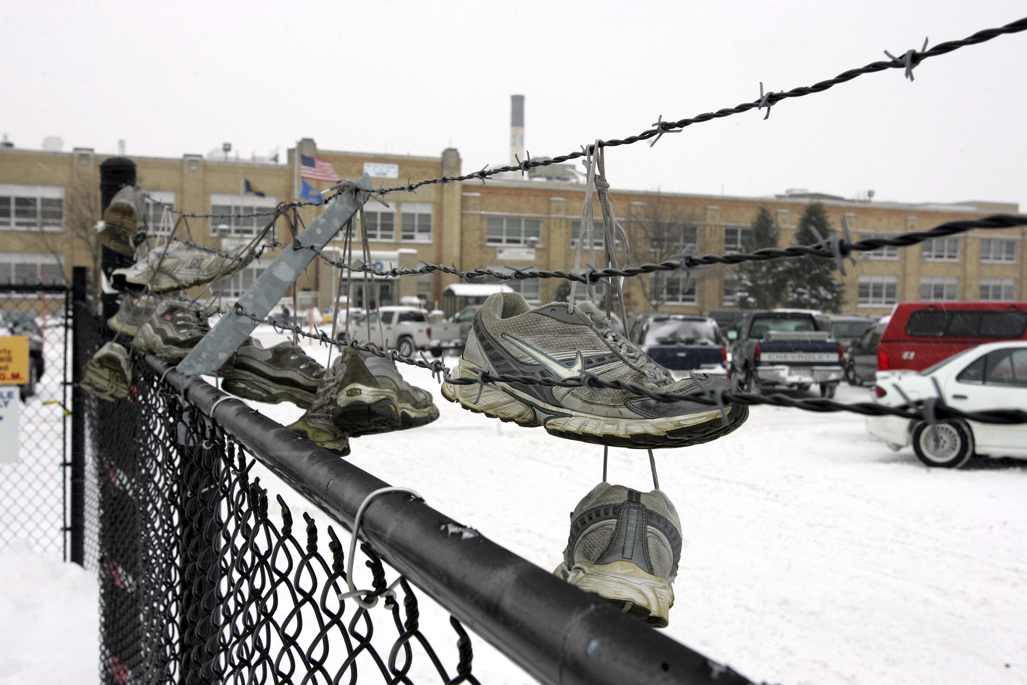 Shoes of autoworkers are hung on a fence at the GM plant in Janesville, Wisconsin, after the last vehicle, a black Chevy Tahoe, rolled off the assembly line December 23, 2008