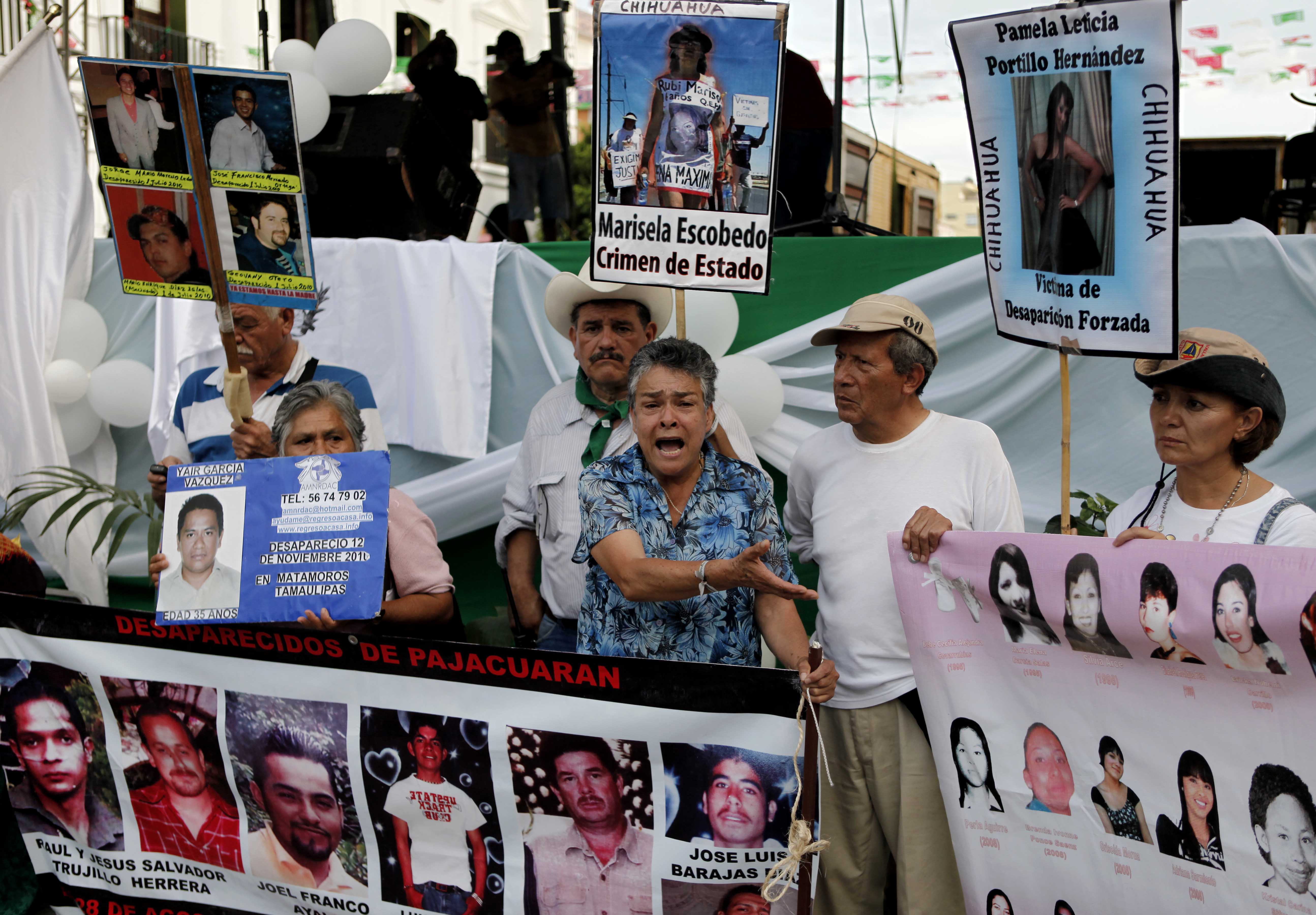 People, holding up images of alleged victims of drug gangs, demonstrate at a meeting during the "Caravan for Peace with Justice and Dignity" tour that travelled through cities and states in southern Mexico affected by drug-related violence. The members of the Caravan were subject to harassment