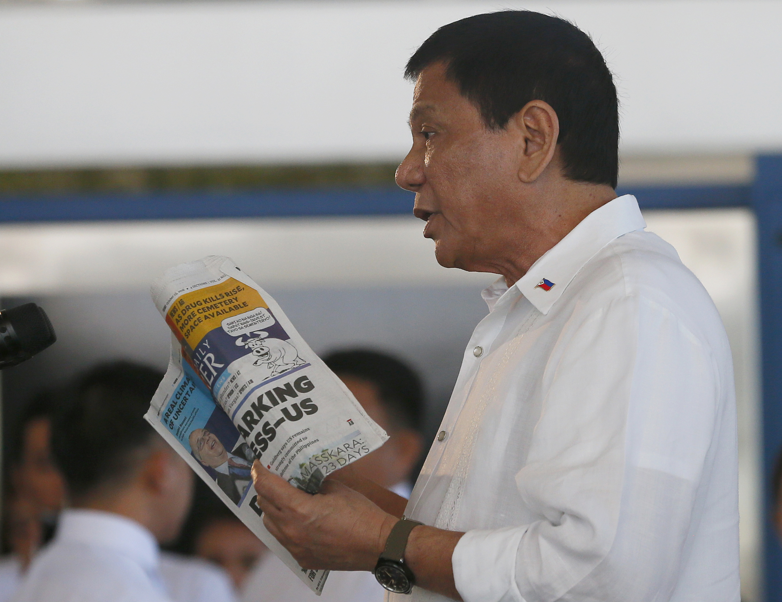 Philippine President Rodrigo Duterte holds a copy of the Philippine Daily Inquirer with the headline: "Duterte sparking international distress-U.S." during a news conference in 2016