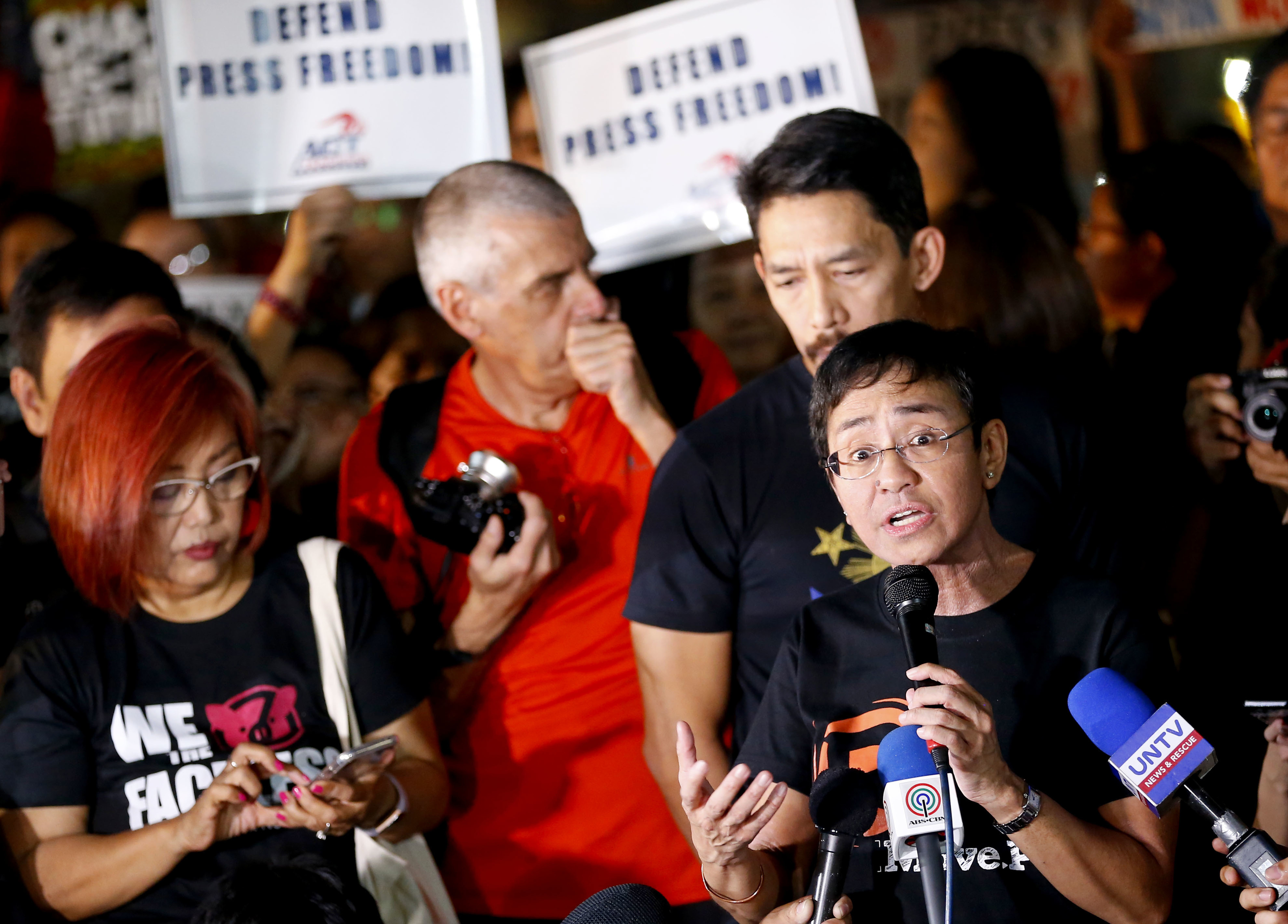Maria Ressa, right, CEO of Rappler, an online news agency, addresses a rally of Philippine journalists and supporters in Quezon City as they protest the recent Securities and Exchange Commission's revocation of its registration in January