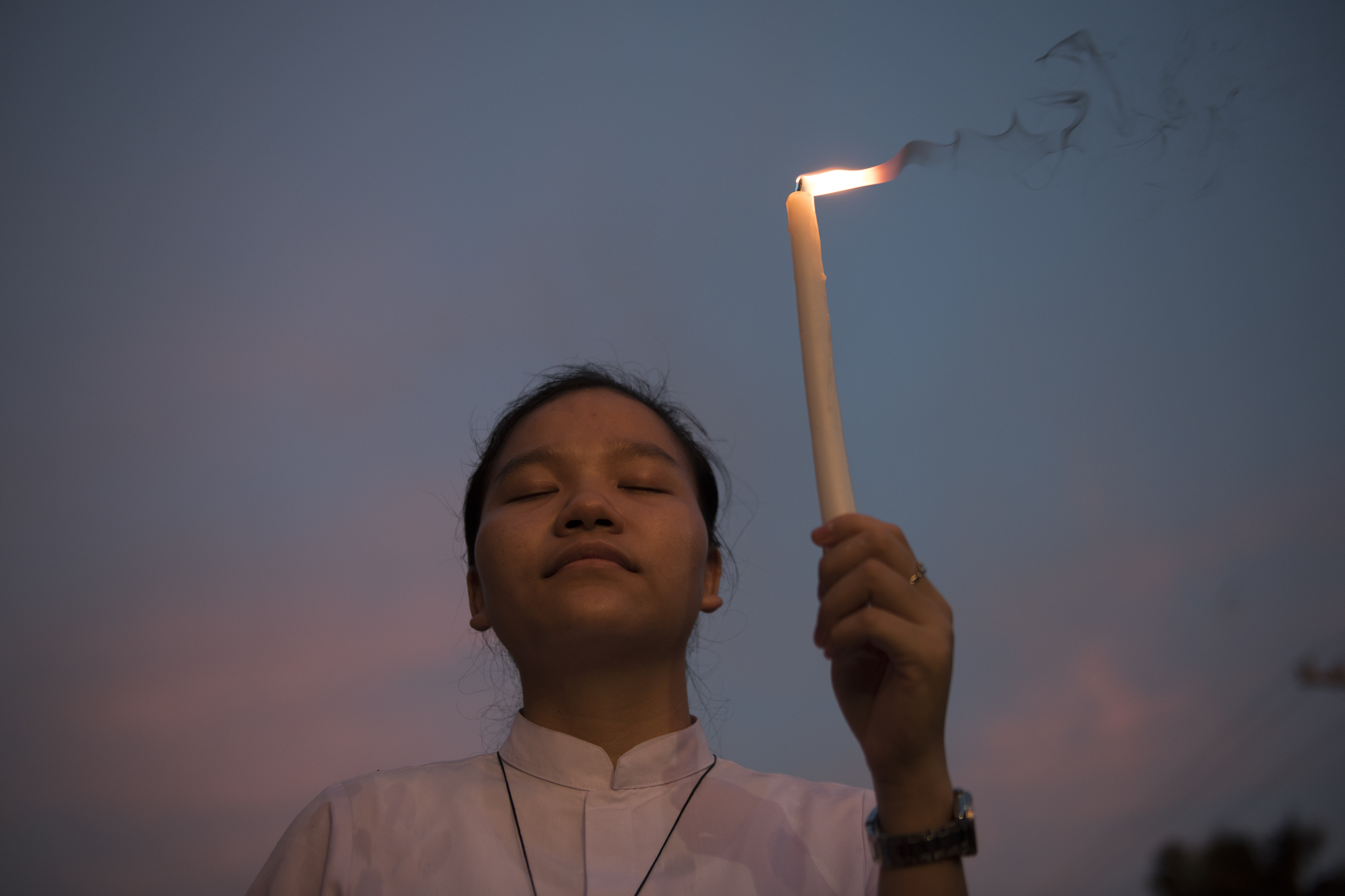 A woman holds a candle at a prayer protest calling for an end to drug-related killings in Manila in November 2017