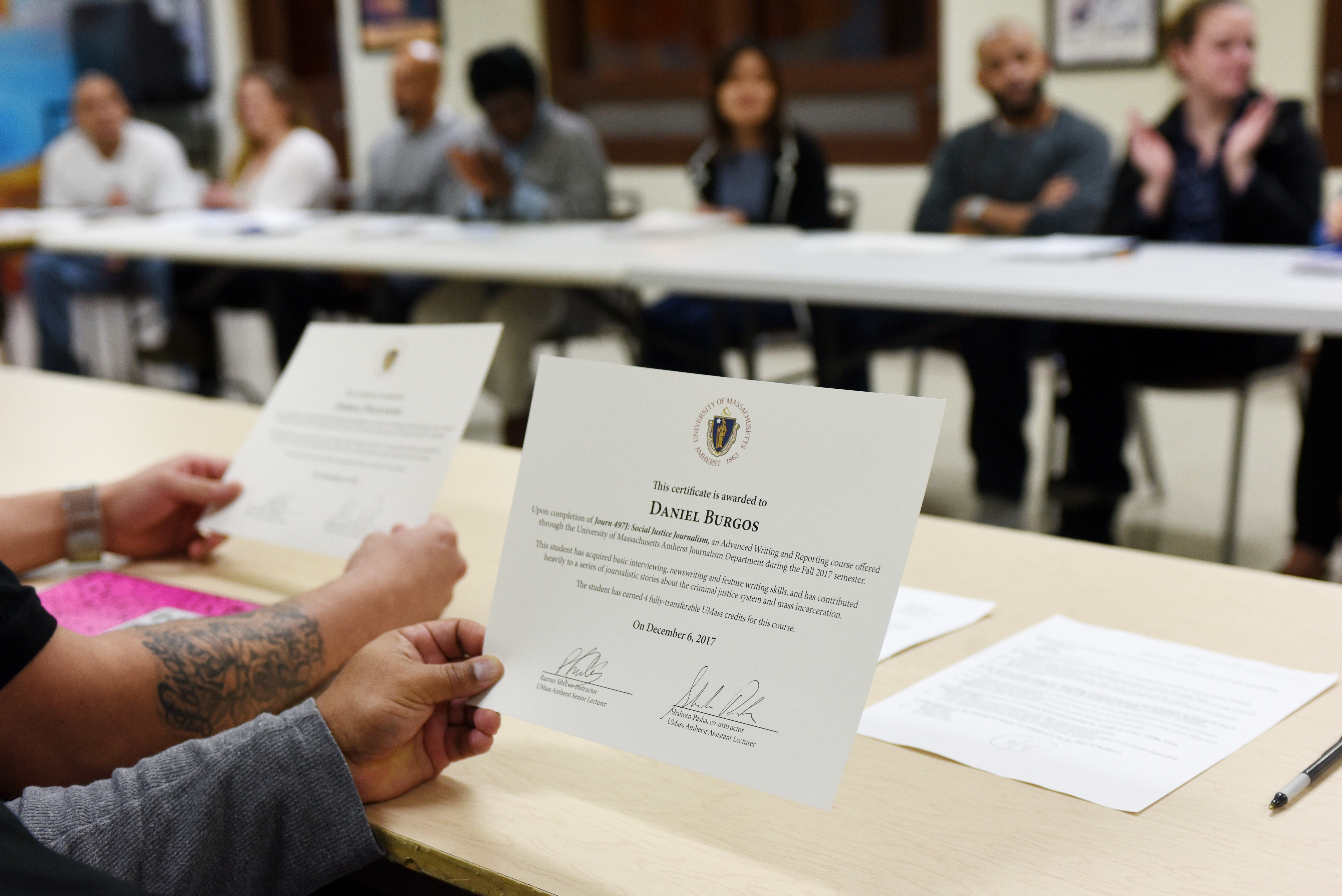 Inmate Daniel Burgos holds his certificate of competition on the last day of the class in December 2017