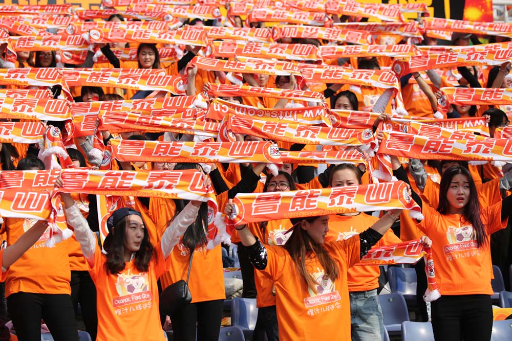 At Jinan Olympic Sports Centre in Jinan, China, fans cheer during a 2016 match between FC Seoul and Shandong Luneng, which is one of many holdings of the Luneng Group