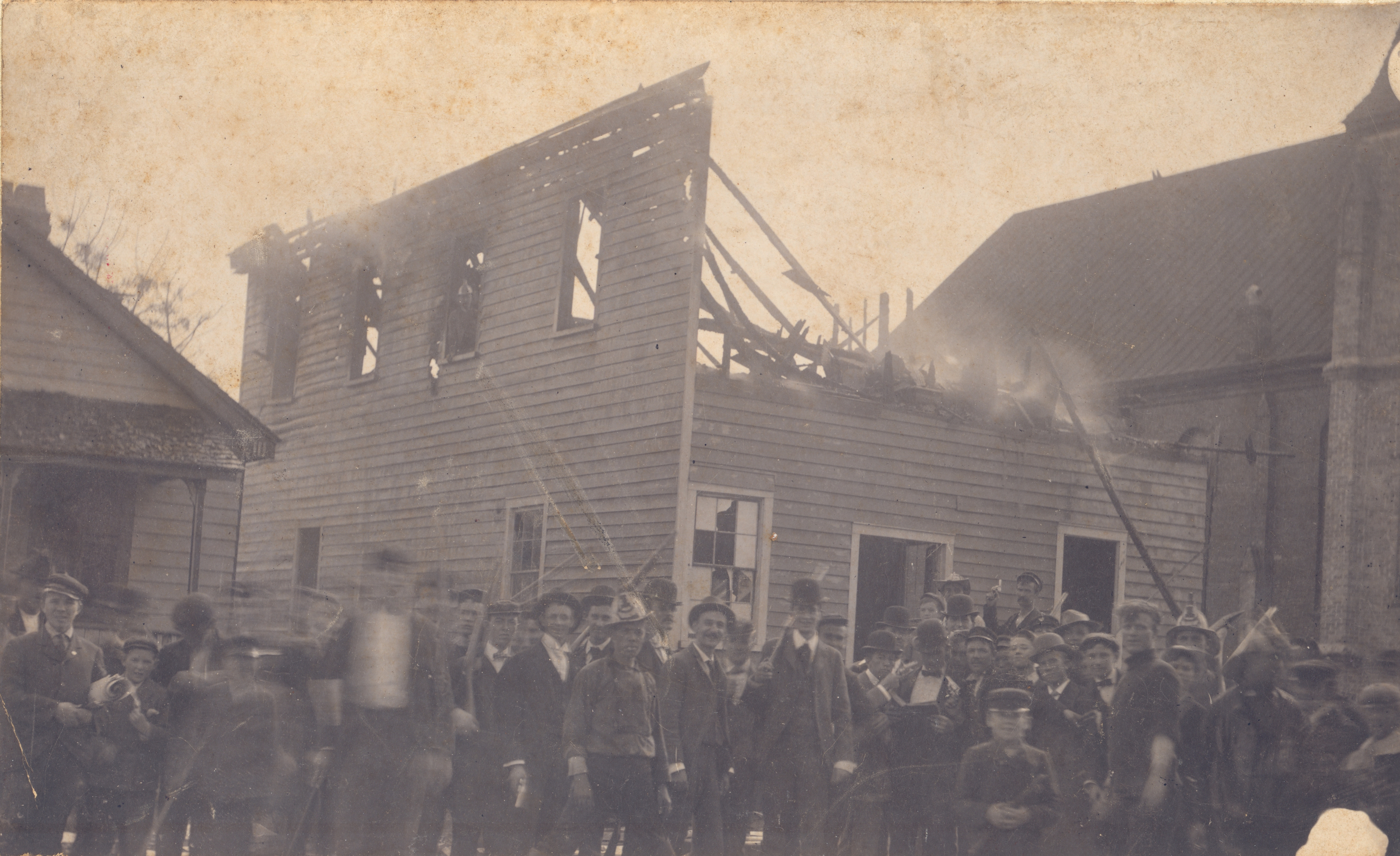White rioters in 1898 stand in front of the burning offices of The Daily Record, a black-owned newspaper in North Carolina