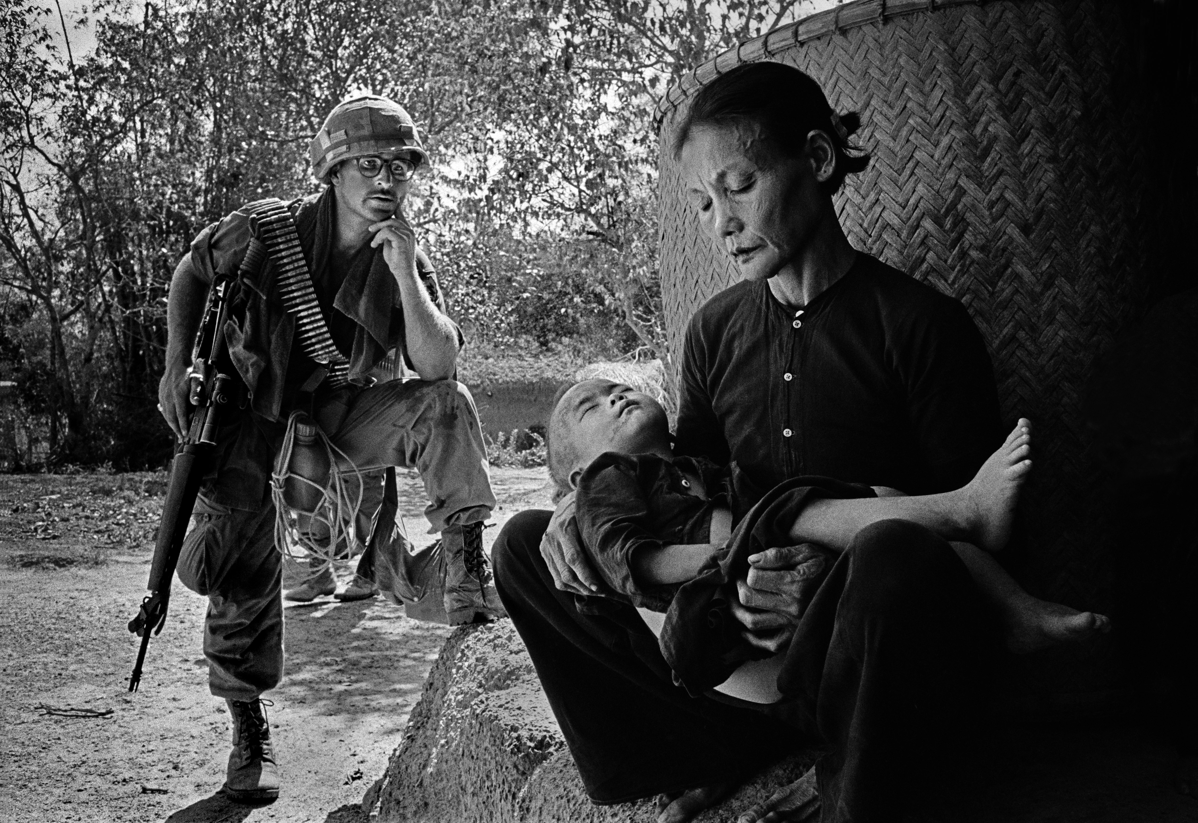 A U.S. serviceman watches a Vietnamese woman and child in a village in Quang Ngai province in 1967