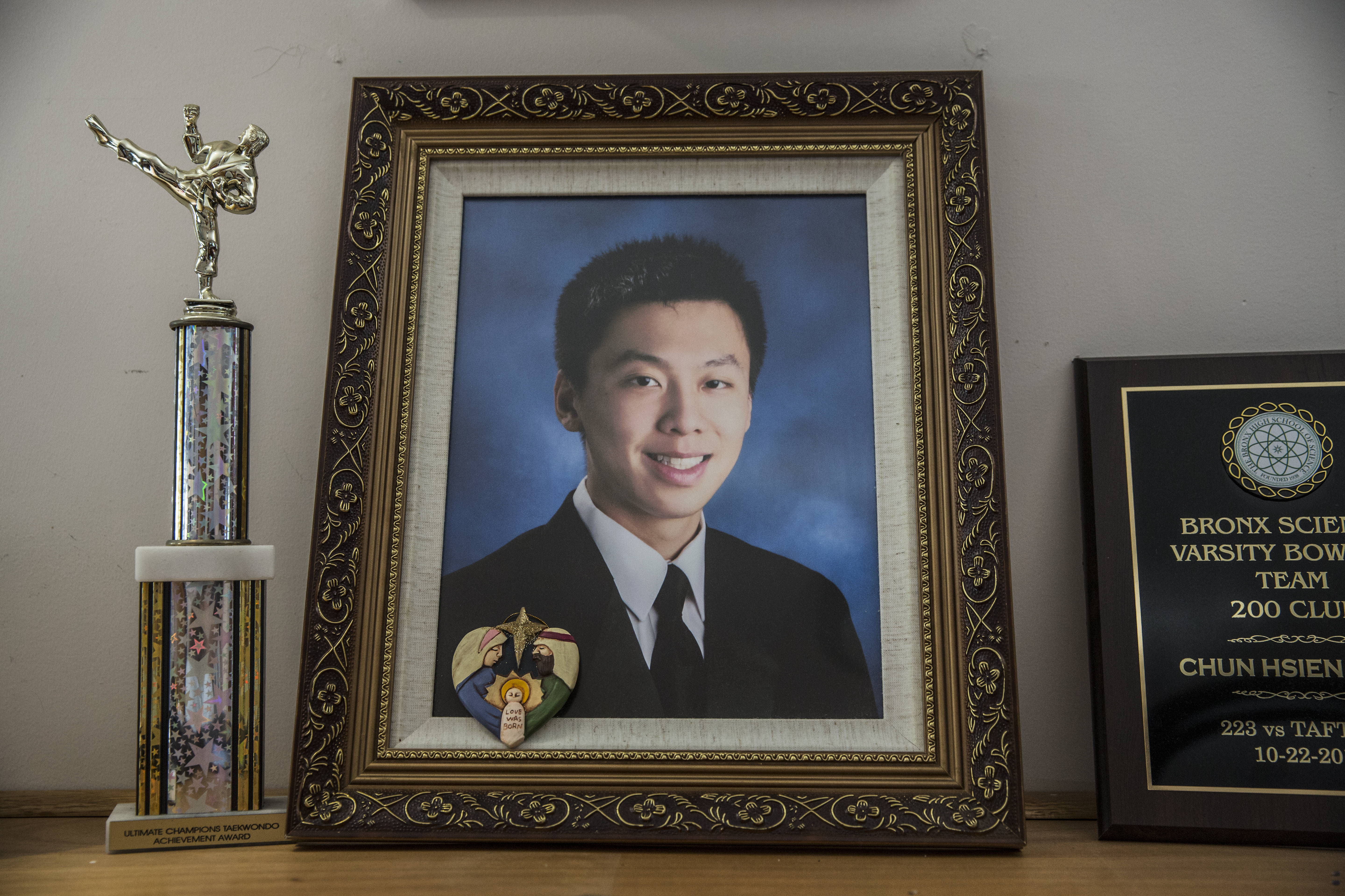 Awards and a photo of Michael Deng, who died after a fraternity hazing ritual,
are displayed at his family’s home in Queens