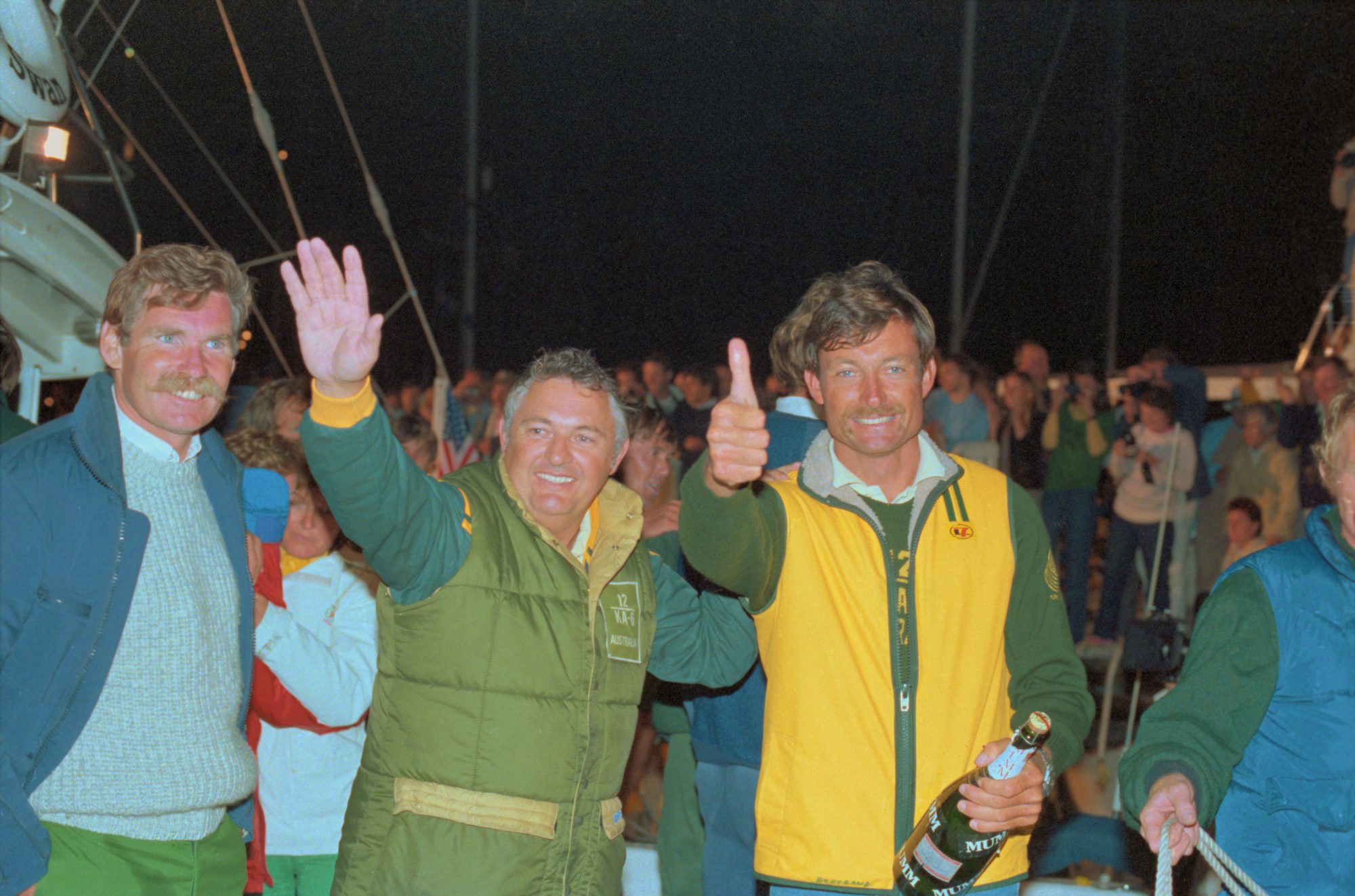Alan Bond and John Bertrand of Australia wave and give a thumbs-up after defeating the U.S. in the 1983 America’s Cup