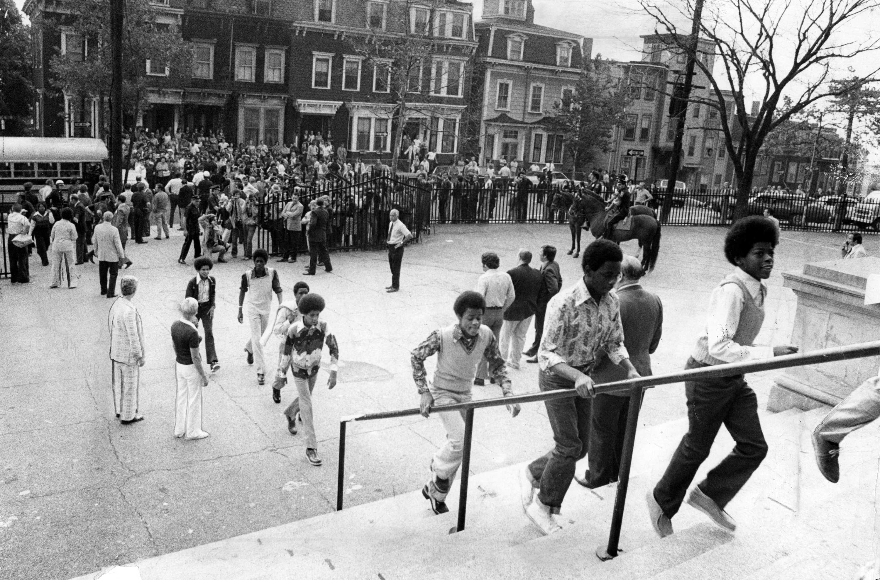 Students enter a South Boston school on the first day of court-ordered busing, imposed to desegregate schools, in 1974