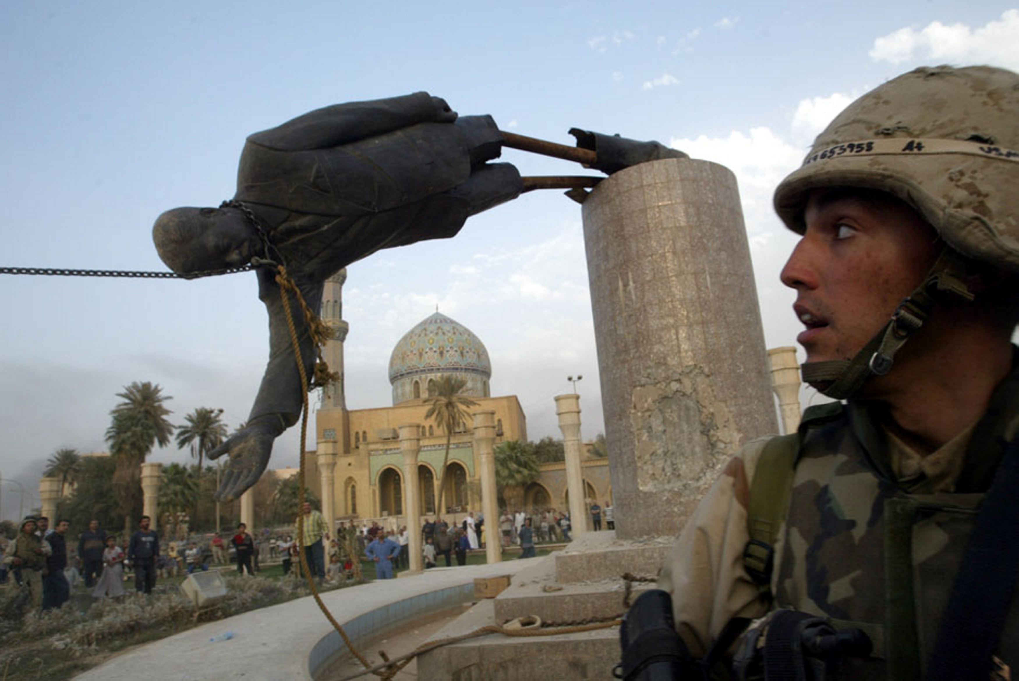 Kirk Dalrymple of the U.S. Marines watches as the statue of Saddam Hussein falls in Baghdad’s Firdos Square in 2003