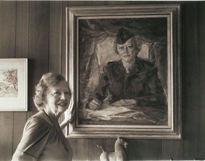 Cowan stands in front of a painted portrait of her in an Army uniform
