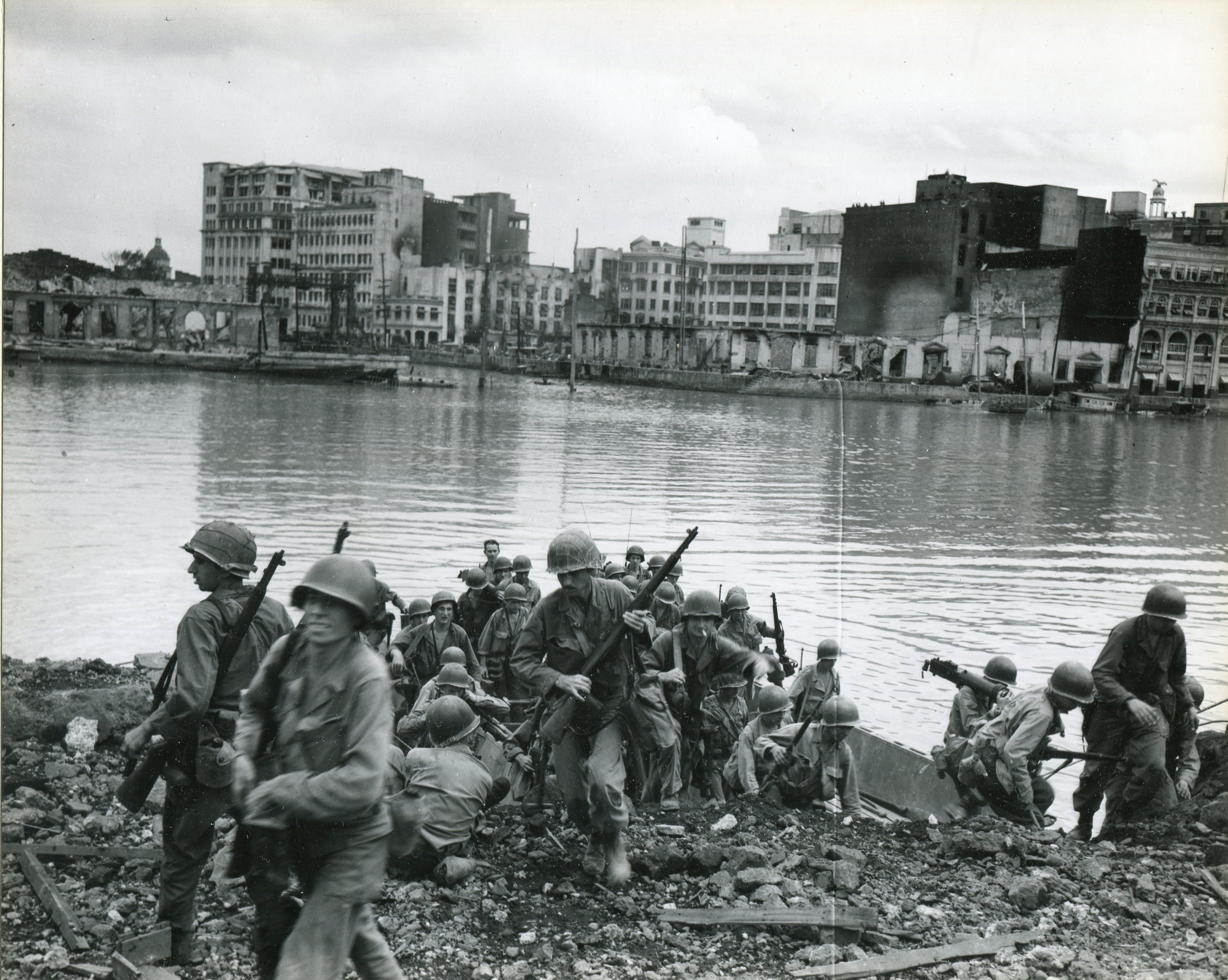 American troops storm the south bank of the Pasig River during the American assault on the Walled City on February 23, 1945 during the Battle of Manila