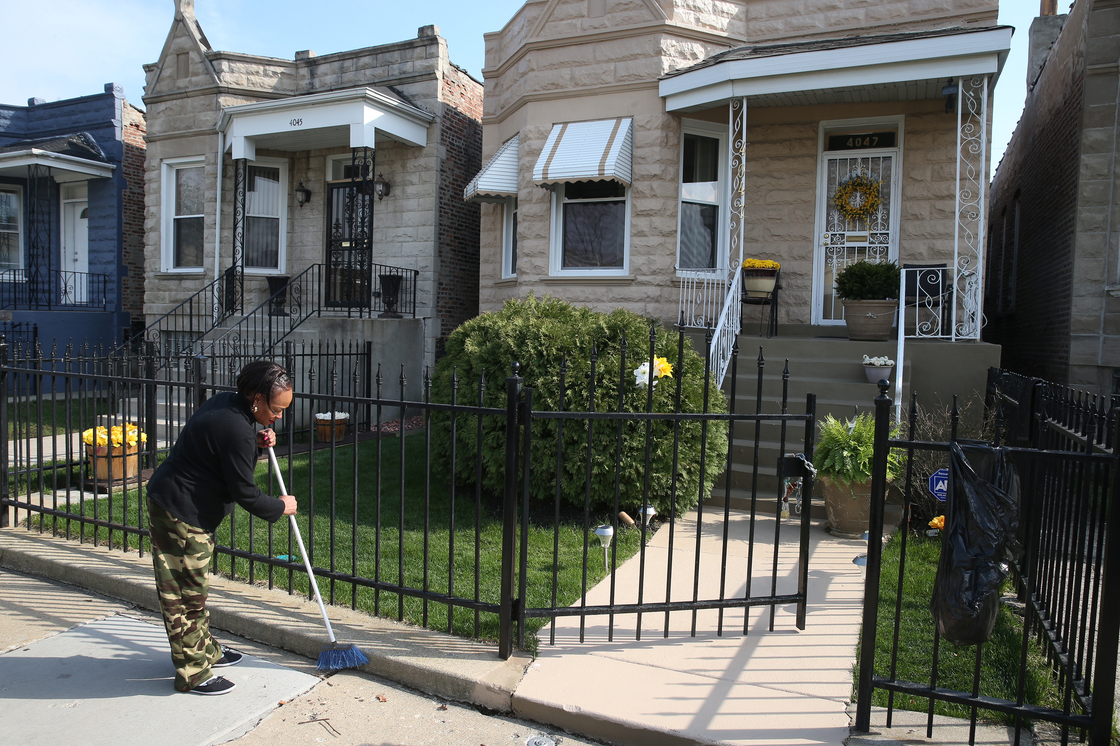 Joan Clark cleans up the sidewalk in front of her Chicago home in April 2017. Several of the homes on her block were assessed at too high a value by the county, a discovery Jason Grotto made while working on his Chicago Tribune/ProPublica Illinois investigative series “The Tax Divide”