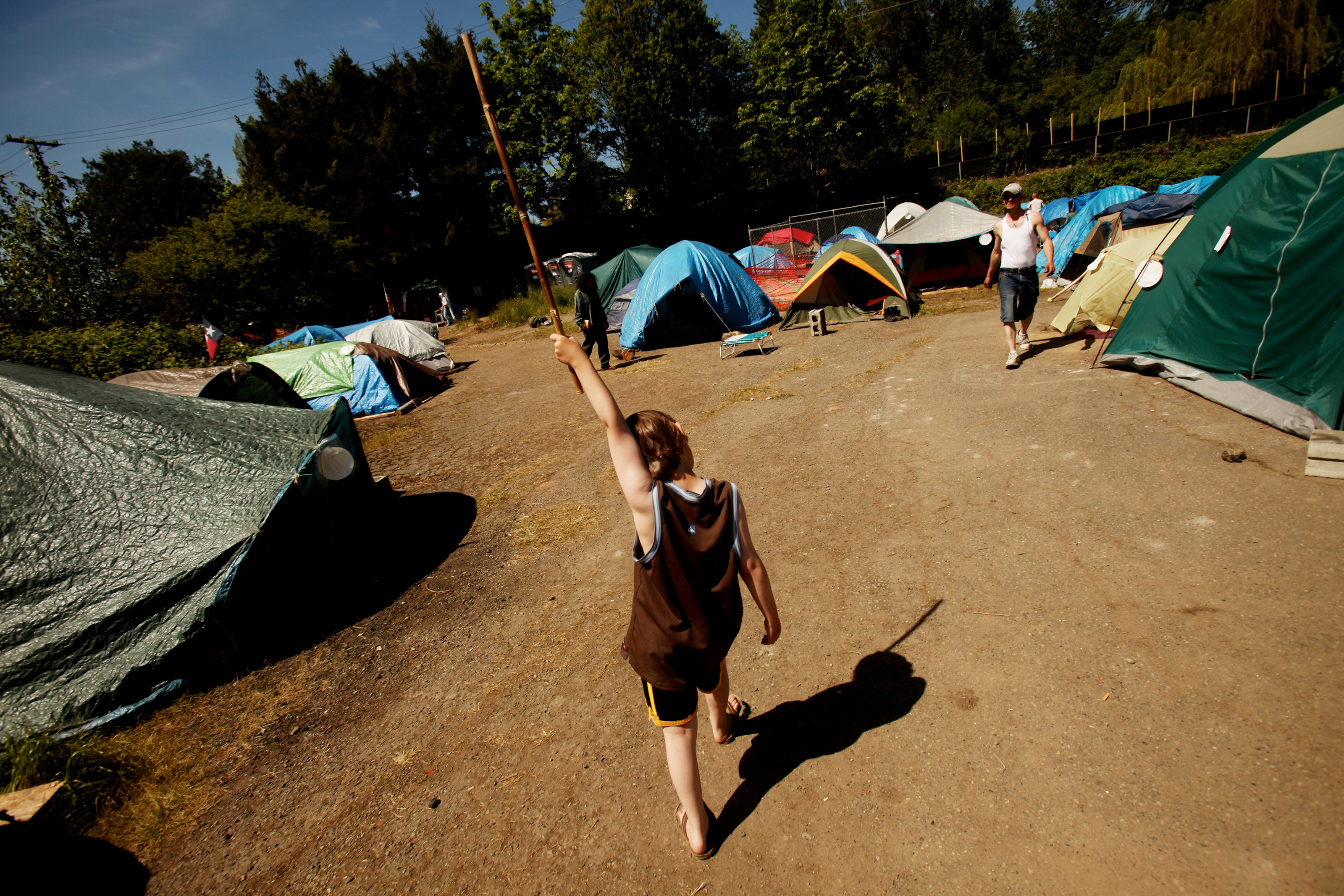 For "Jack's Journey," part of a Seattle Times series on homelessness, Erika Schultz profiled a homeless family, including 9-year-old Jack. Here, Jack marches with a bamboo stick through a tent city they lived in when they first moved from Chicago to Seattle