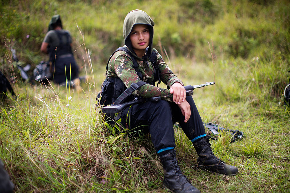 In this January 2016 file photo, Juliana, a 20-year-old rebel fighter for the 36th Front of the Revolutionary Armed Forces of Colombia, or FARC, rests from a trek in the northwest Andes of Colombia, in Antioquia state. After 50-plus years of conflict, the Colombian government and FARC rebels signed a revised peace agreement in November 2016