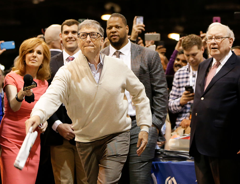 Warren Buffett watches as Bill Gates participates in a newspaper tossing competition, held annually at Buffett's Berkshire Hathaway shareholders meeting, at the CenturyLink Center in Omaha in May 2017. Funding provided by private foundations such as the Bill and Melinda Gates Foundation is essential for the the most widely-read nonprofit news outlets specializing in coverage of humanitarian affairs